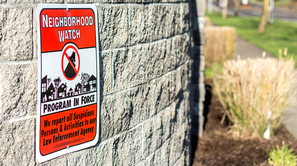 Eugene,Oregon, USA - December 13, 2014: Orange & Black Neighborhood Watch Sign displayed in neighborhoods warning potential thieves that the neighborhood will be observant to all suspicious behavior causing a effective deterence to crimes.
